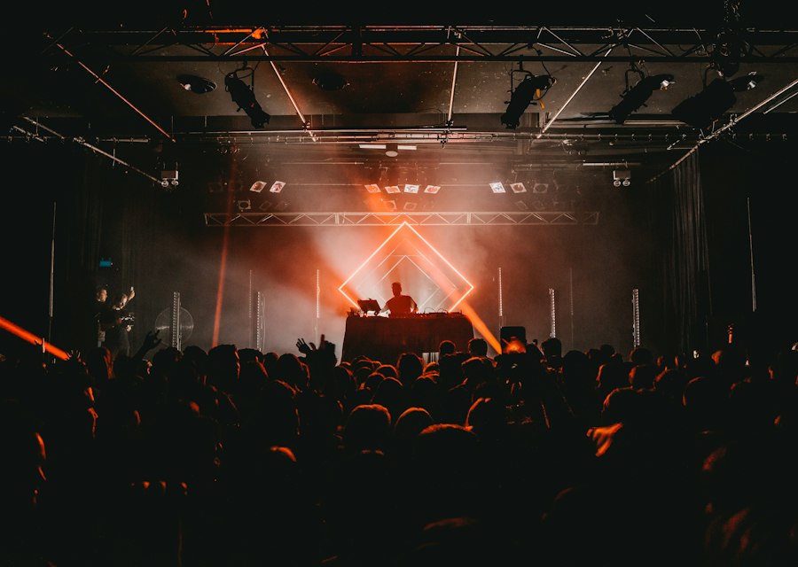 DJ in einem dunklen Club mit roten Lichtern über der Crowd