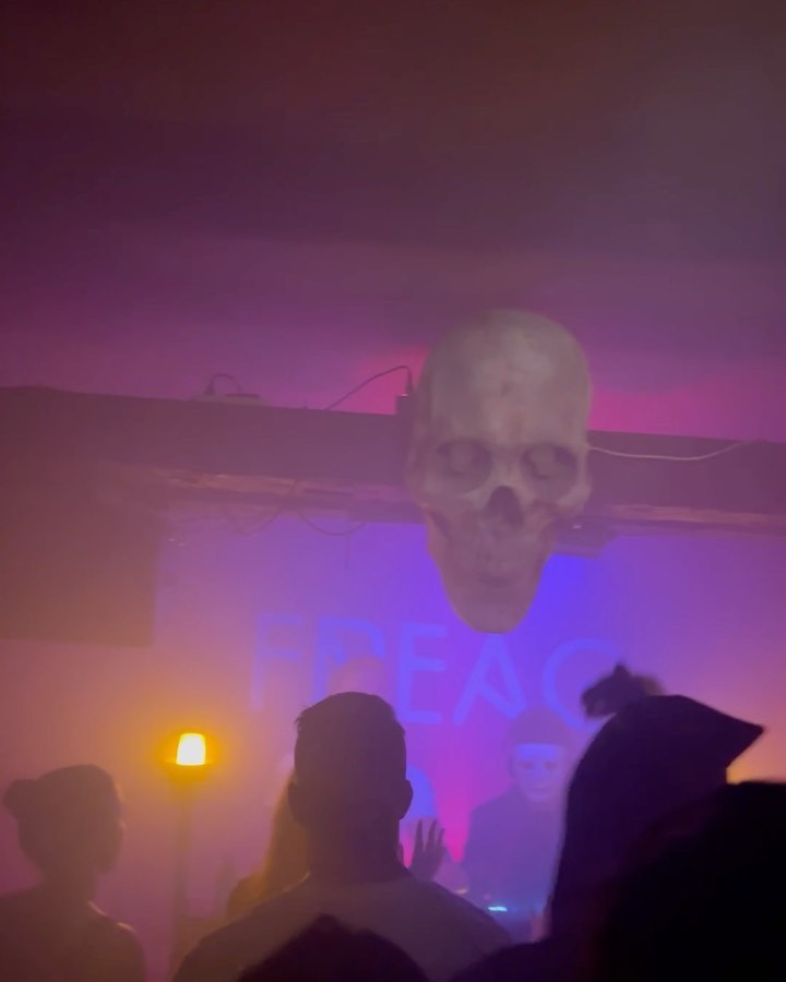 Neblige Clubnacht mit Totenkopf-Deko über dem DJ-Pult