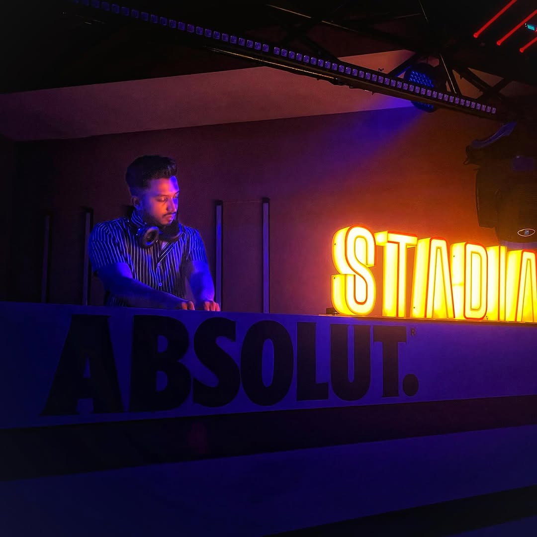 Basstian auf der Bühne mit Neon-Schriftzug im Hintergrund